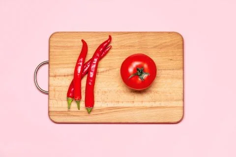 Three Fresh Red Chilli Pepper Near One Tomato Stock Photos