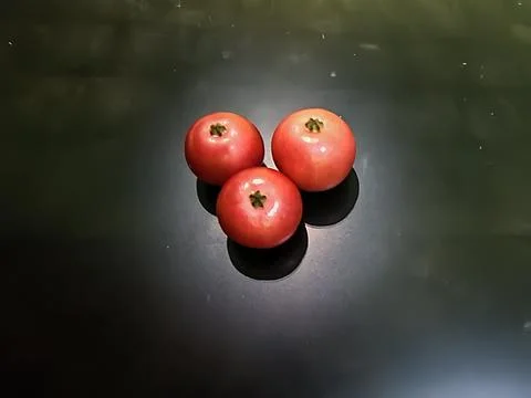 Three Fresh Red Pomegranates with Dramatic Shadows on Dark Background Stock Photos
