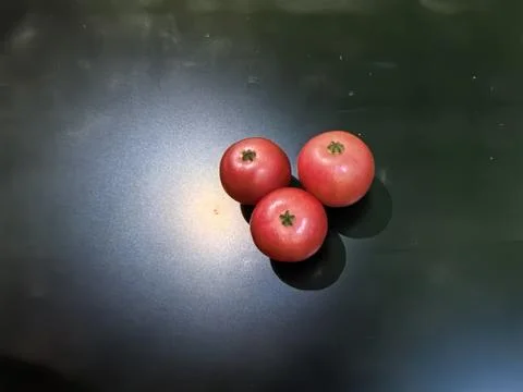 Three Fresh Red Pomegranates with Dramatic Shadows on Dark Background Stock Photos