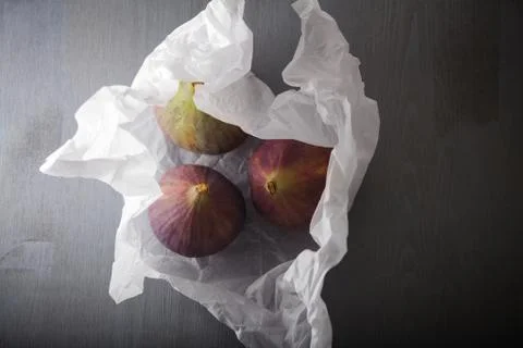 Three fresh ripe Figs lying on a stone surface Stock Photos