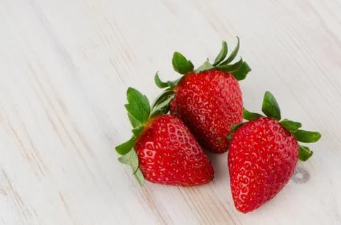 Three fresh strawberries Stock Photos