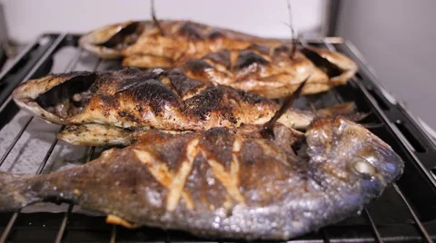 Three fried dorados on a grill grid. Handheld shot of fish 스톡 동영상 68991292