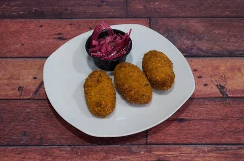 Three fried dough balls on a white plate Stock Photos