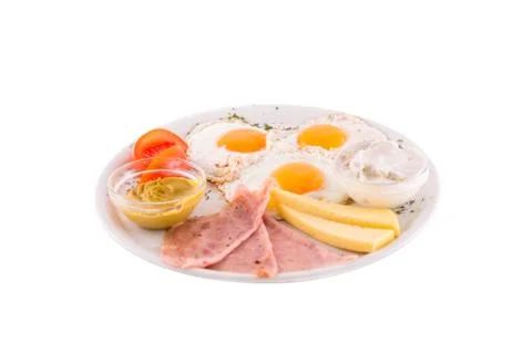 Three fried eggs garnished with cheese, ham and tomatoes Stock Photos