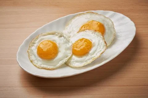 Three fried eggs Stock Photos