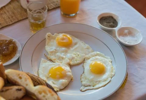 Three fried eggs on white plate for breakfast Stock Photos