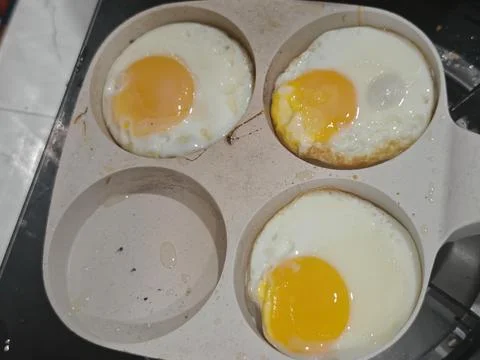 Three Fried Sunny Side Up Eggs in a Specialized Multi-Mold Frying Pan Stock Photos