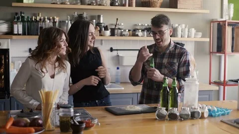Three friend are talking on a home kitchen party with beer Stock Footage 73594440