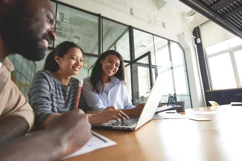 Three friendly coworkers looking at computer screen Stock Photos