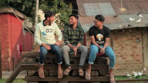 Three friends are sitting together and chatting Stock Footage 296282910