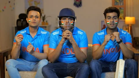 Three friends are watching a live cricket match on television - praying for t... Stock-Footage 253140604