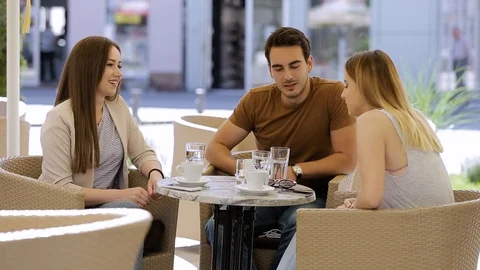 Three friends in caffe sitting and talking about something Video stock 87392072