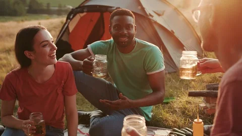 Three friends in camp while celebrating by drinking a beer in a moment of Stock-Footage 97255464