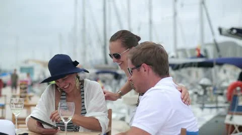Three friends chatting on tablet computer at marina, steadycam shot Stock Footage 11299865