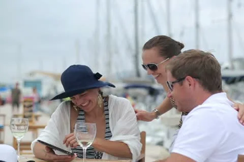Three friends chatting on tablet computer at marina, steadycam shot Stock Footage 11303397