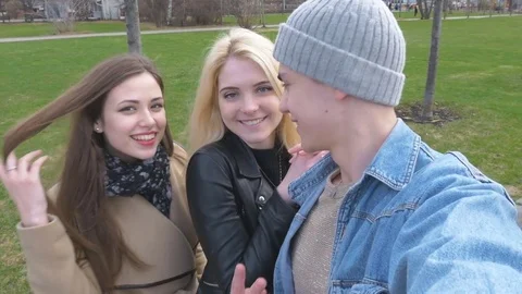 Three friends, do selfie for a walk in the park. Blonde, brunette and a young Stock Footage 75031969