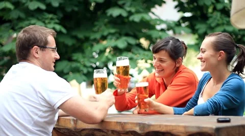 Three friends drinking beer and talking, outdoors 스톡 동영상 7903524