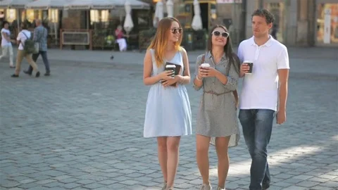 Three Friends Drinking Coffee and Walking around the City During Summer Warm Day Stock Footage 79846057