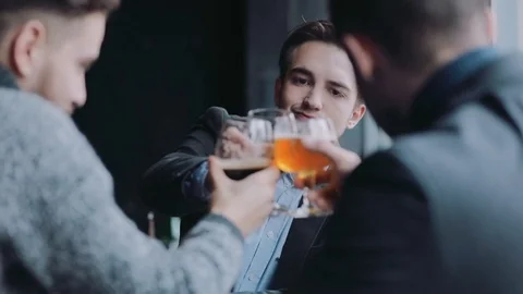 Three friends enjoying the beer, make a toast, have a sip of the beer Video stock 74801327