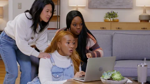 Three friends excitedly react to something on a laptop, sharing joy and laughter Stock Footage 308042567