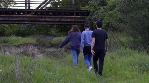 Three friends going for a railroad bridge in wilderness in slow motion Stock Footage 134015055