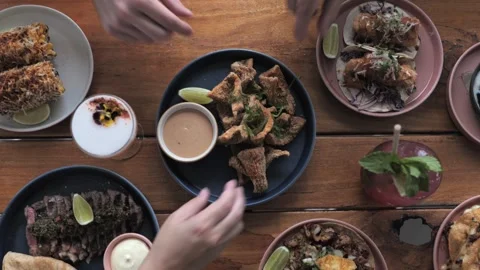Three Friends Grabbing Calamari at the Same Time on a Table Full of Mexican Food Stock Footage 305022105