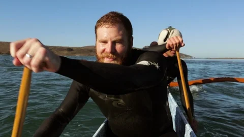 Three friends have fun in their canoe on the ocean. Stock Footage 88405768