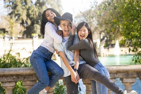 Three friends having fun visiting a landmark and looking at the camera Stock Photos