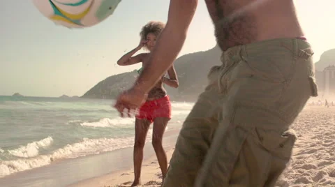 Three friends playing football on Ipanema beach Stock Footage 59377204