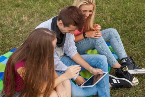 Three friends playing game on tablet pc. They winning again. Stock Photos