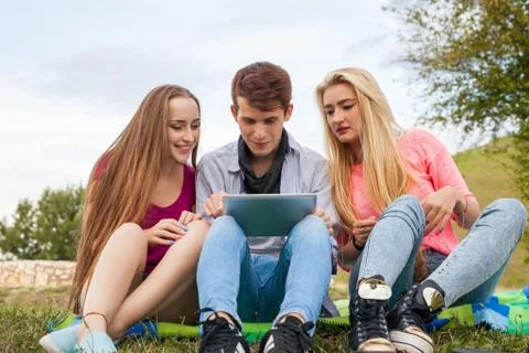 Three friends playing game on tablet pc. They winning again. Stock Photos