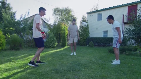 Three friends plays with ball on backyard at summer time Video stock 143490074