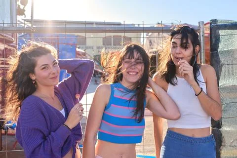 Three friends posing amusingly while eating lillipop outdoors Stock Photos