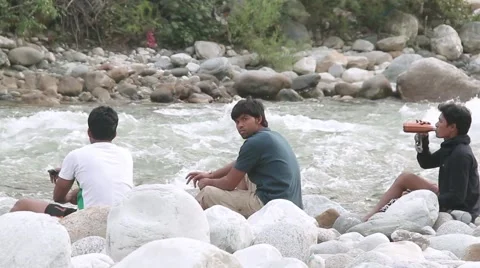 Three friends relaxing by riverside Stockbeeldmateriaal 45307463