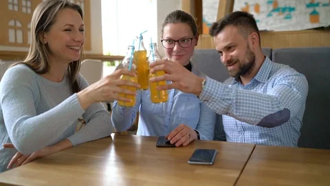Three friends sit in a cafe, drink juice and have fun communicating. Slow motion Stock Footage 89067100