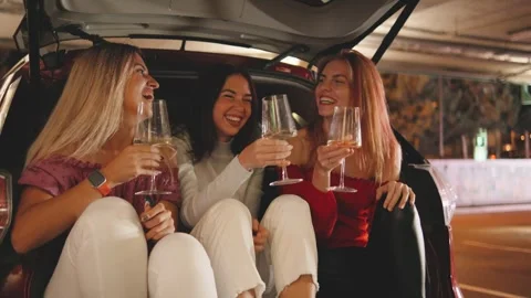 Three Friends Sit in the Trunk of a Modern Car, Clinking Glasses and Drinking Stock-Footage 288504641