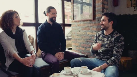Three friends smiling and talking in a cafe Stock-Footage 95907490