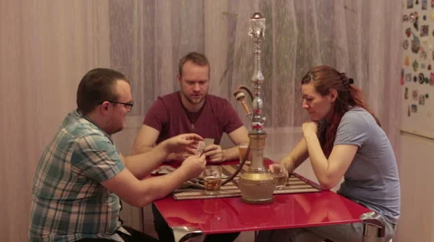 Three friends smoking shisha and playing cards Stock Footage 59582551