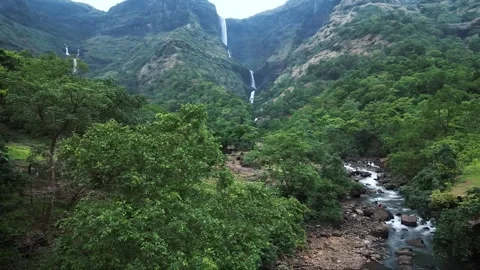Three Friends Standing Below, Watching Mountains and Waterfall Stock Footage 285075398