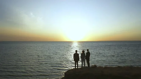The three friends standing on the mountain edge against the seascape Stock Footage 143896275