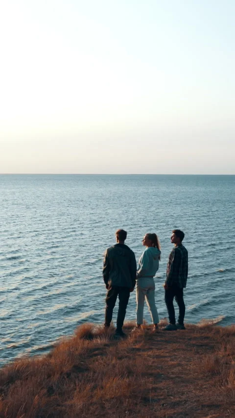 The three friends standing on the mountain top above the sea Stock Footage 242239357
