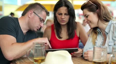 Three friends with tablet computer sitting in the restaurant, steadycam shot Stock Footage 12133910