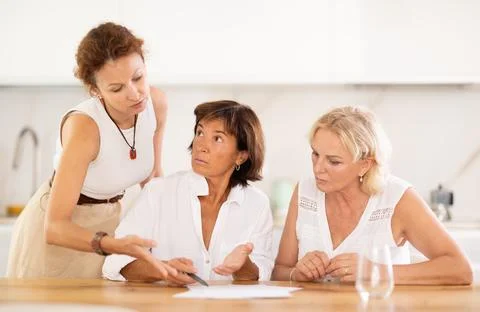 Three friends try to solve financial problems together by discussing documents Foto stock