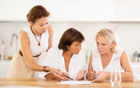 Three friends try to solve financial problems together by discussing documents Fotos Stock