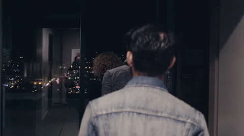 Three friends walk out onto a rooftop balcony to start a party. 60995412