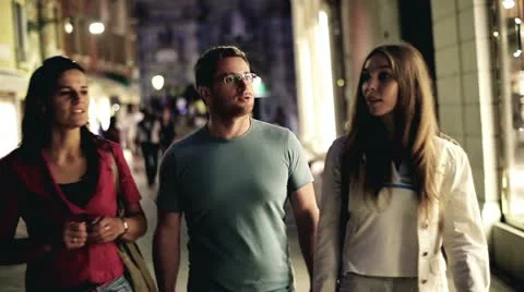 Three friends walking in the old town in the evening Stock Footage 12317628