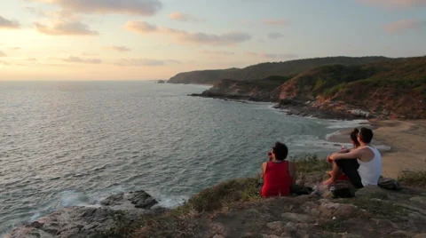 Three friends watching the sunset in the Oaxaca coast. Stock Footage 49672270