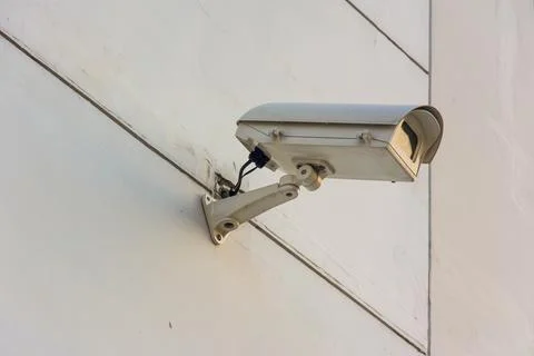 Three frontal view security cameras on a concrete wall. Stock Photos