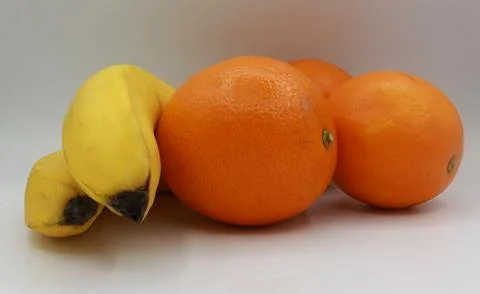 Three fruit composition including two bananas and two oranges positioned Stock Photos