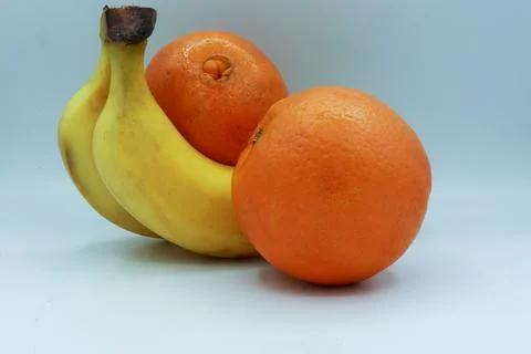 Three fruit composition including two bananas and two oranges positioned Stock Photos